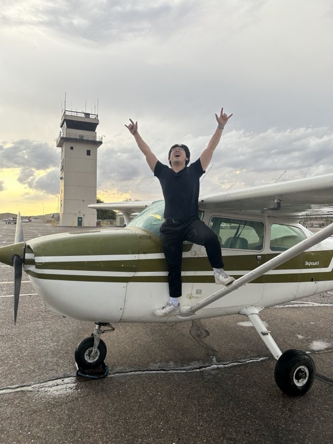 A student celebrating on the cowling of N1287U after a first solo